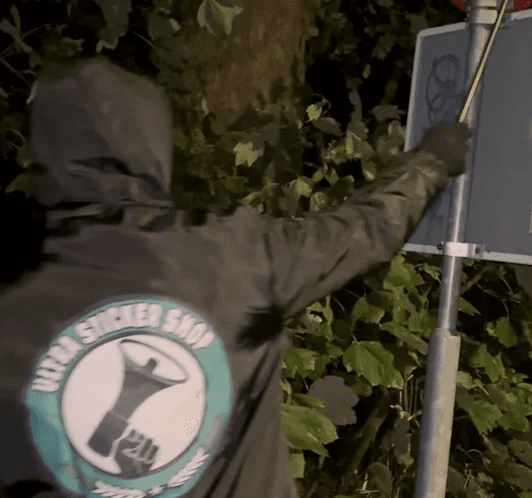 Ultra Sticker Shop supporter applying a sticker outdoors